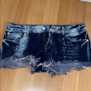 Splattered jean shorts with light pink fringe